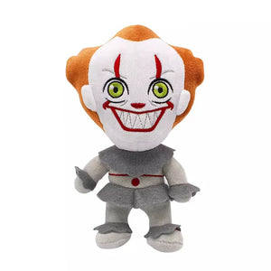 A Pennywise the Clown plush toy with orange hair, a white face, green eyes, and a wide red grin, wearing a gray and white outfit against a plain white background.