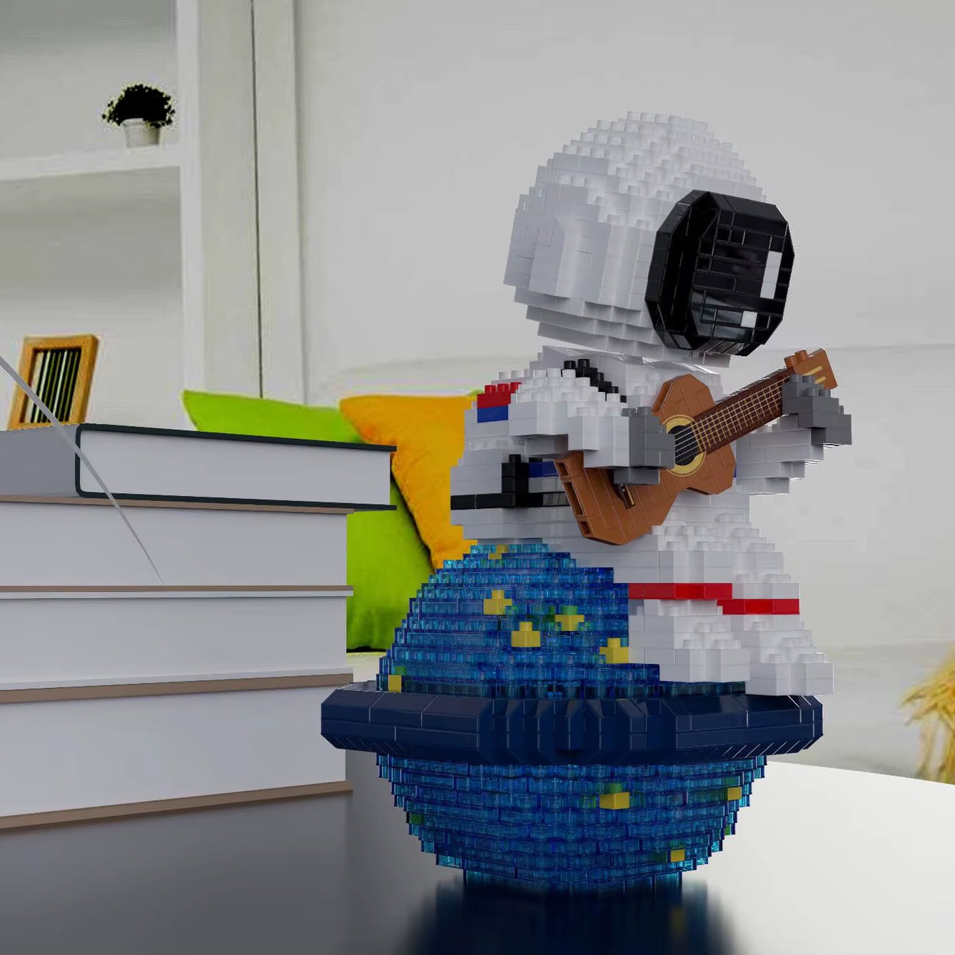 Side view of astronaut guitar building block model with LED base displayed on desk near books