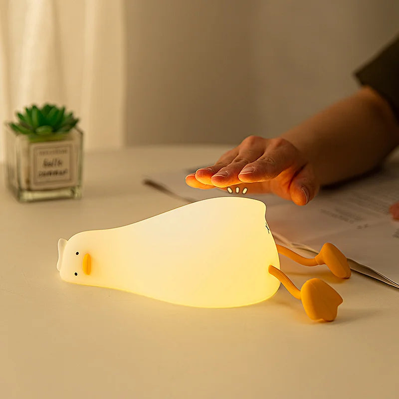 Hand pressing the soft silicone duck night light to turn it on
