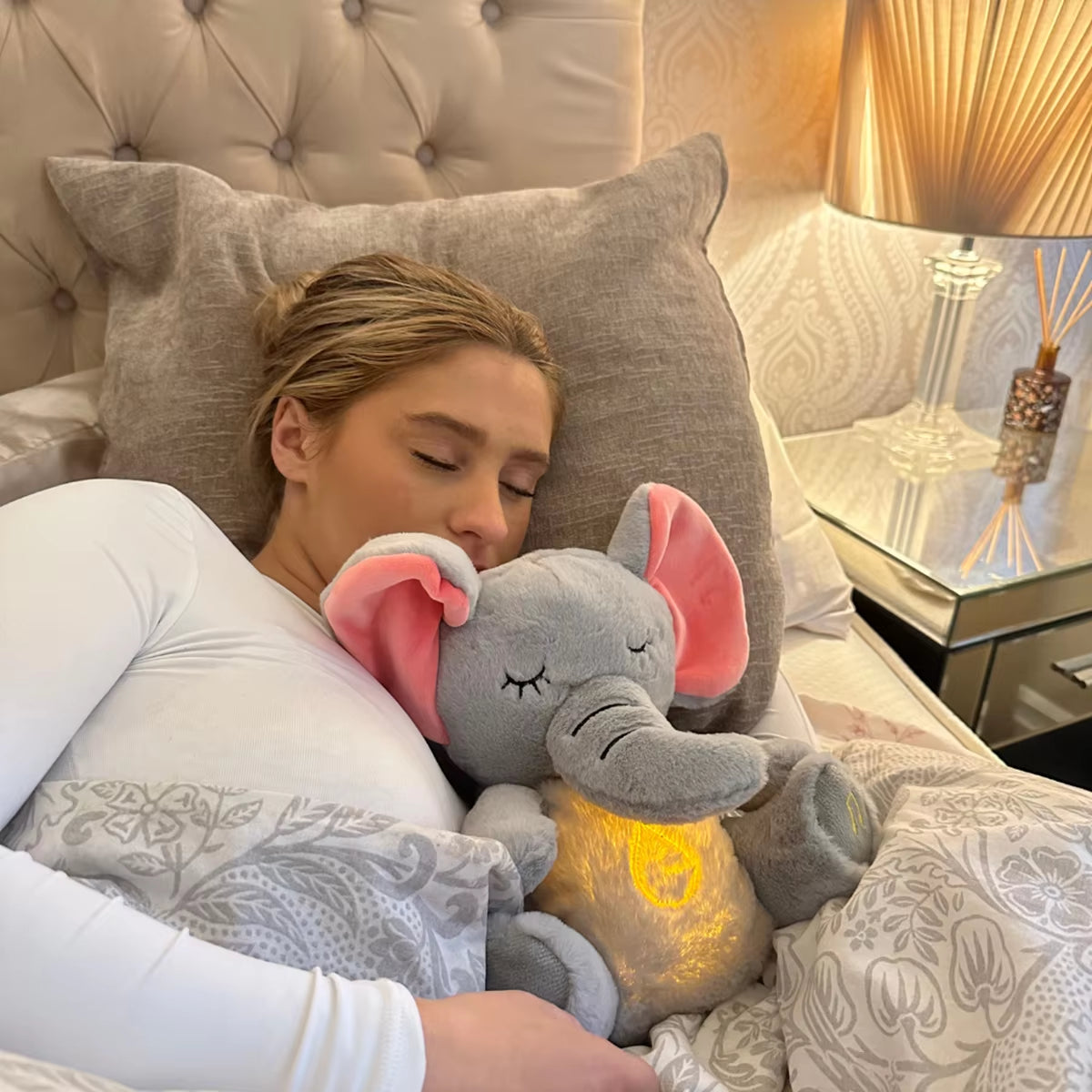 Young girl hugging a breathing elephant plush sleep companion