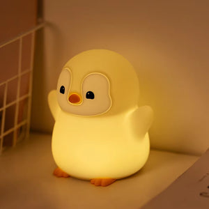 Penguin night light glowing softly in a dark nursery