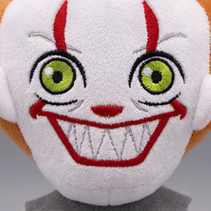 Close-up of Pennywise plush face showing embroidered eyes and toothy grin