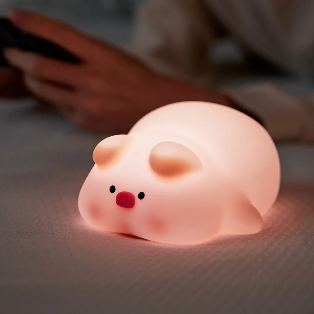 Pink pig night light displayed on a bedside table with a soft glow