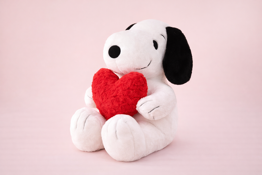 Soft Snoopy plush dog holding red heart, romantic stuffed animal gift on pastel background