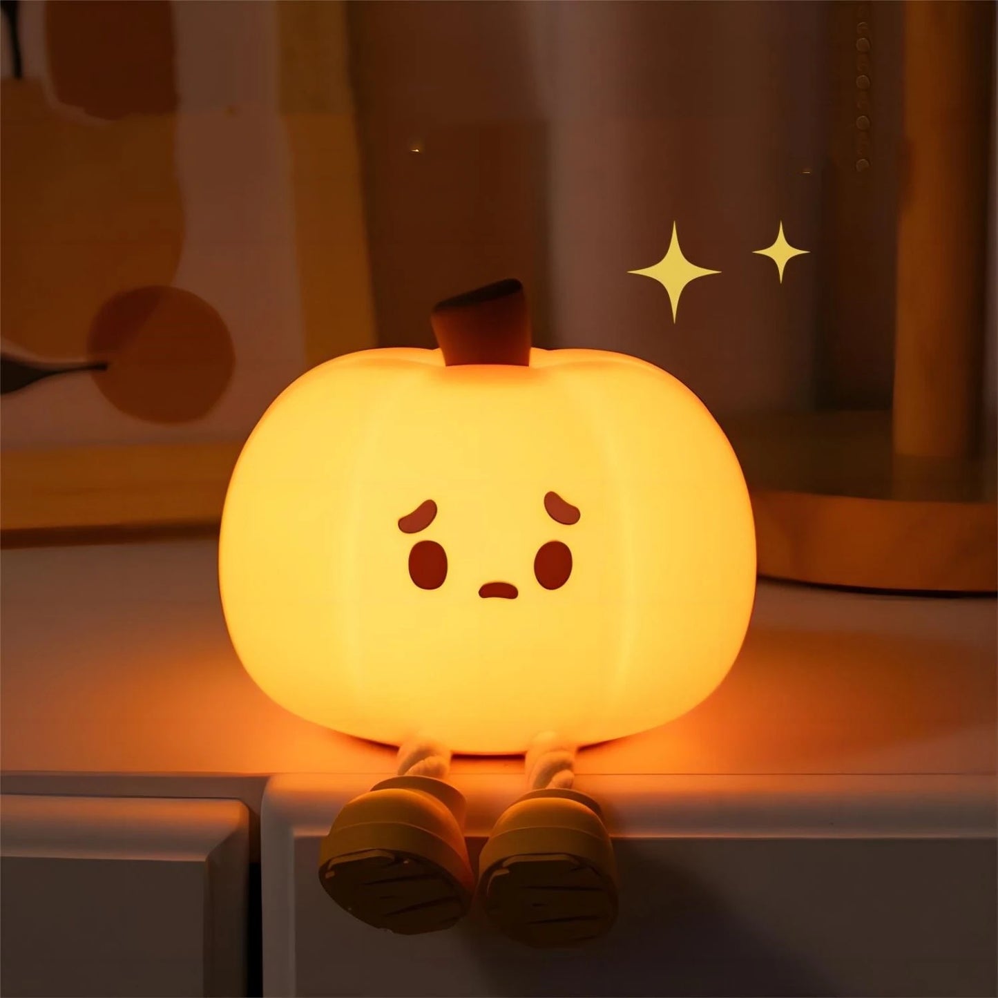 Little pumpkin LED night light glowing warmly in a dark room