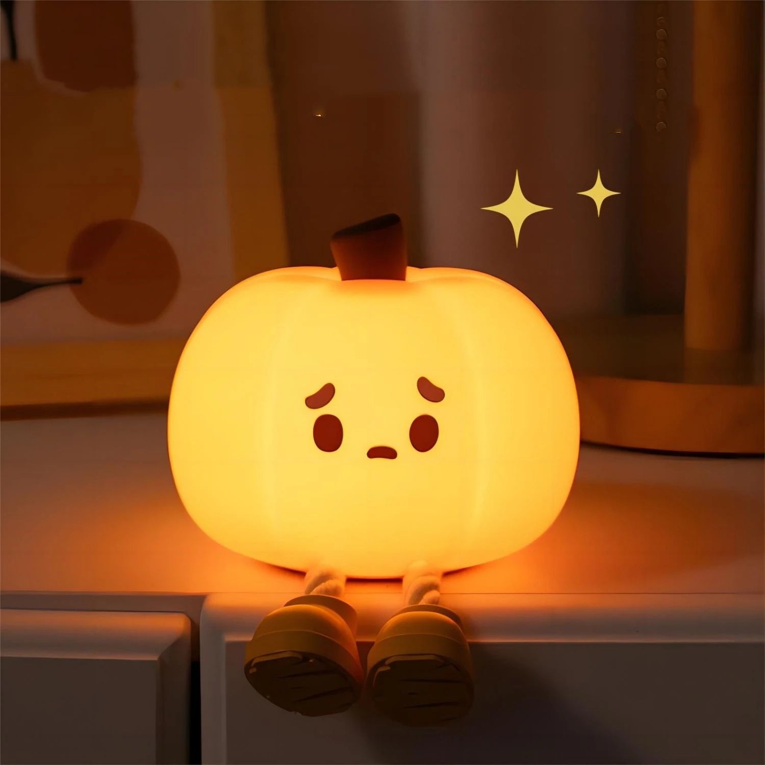 Little pumpkin LED night light glowing warmly in a dark room