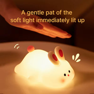 Hand tapping the big face rabbit night light to turn it on