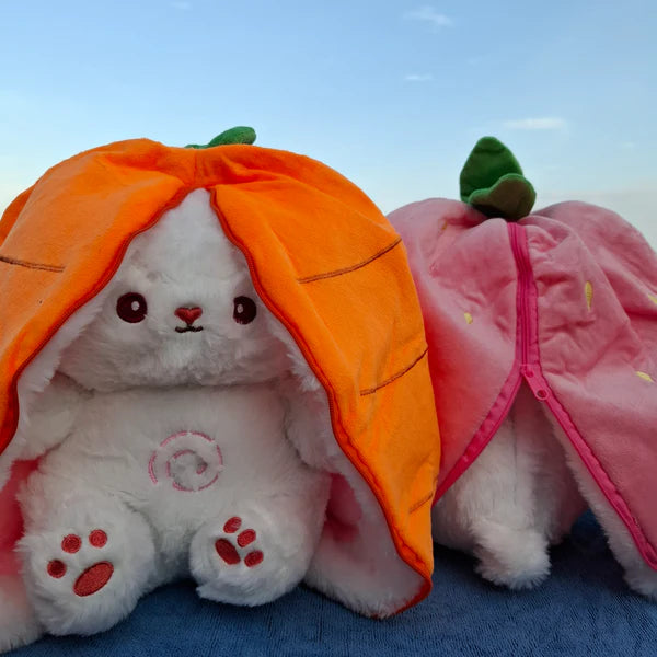 Carrot and strawberry radish bunny plush toys on the beach from the back