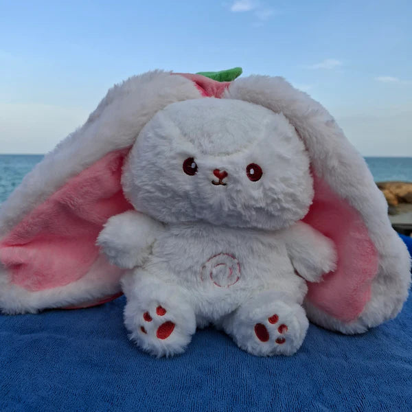 Radish bunny breathing plush toy placed in a beach setting