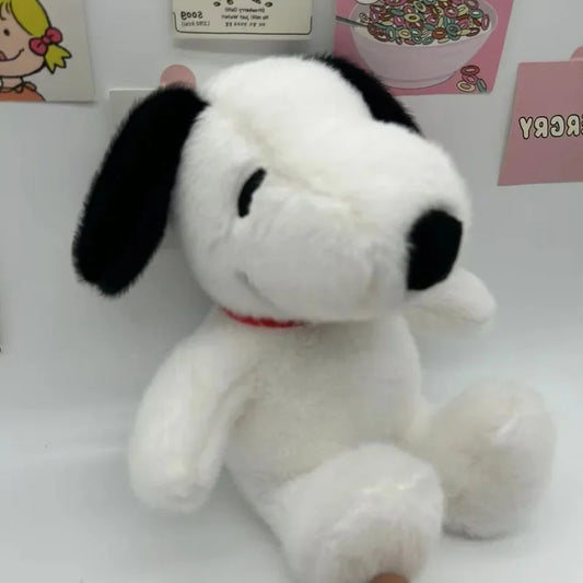Snoopy plush toy displayed on a bed with a soft and cozy look