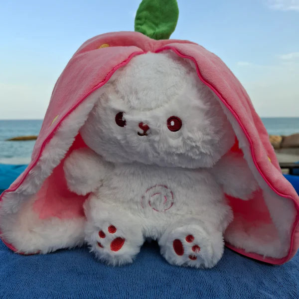 Strawberry radish bunny breathing plush toy sitting on the beach