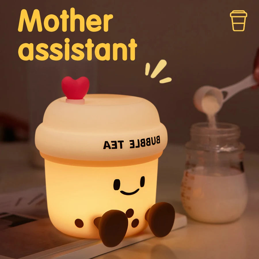 The Boba Night Light glowing softly beside a baby bottle, shown as a helpful bedside light for nighttime care.