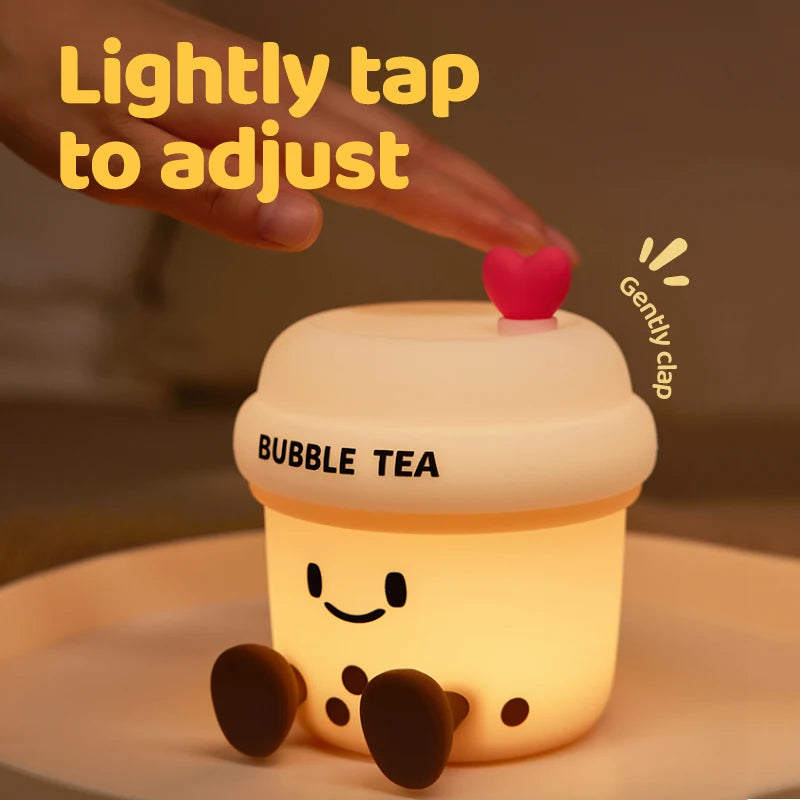 The Boba Night Light glowing warmly as a hand lightly taps the heart button to adjust the brightness.